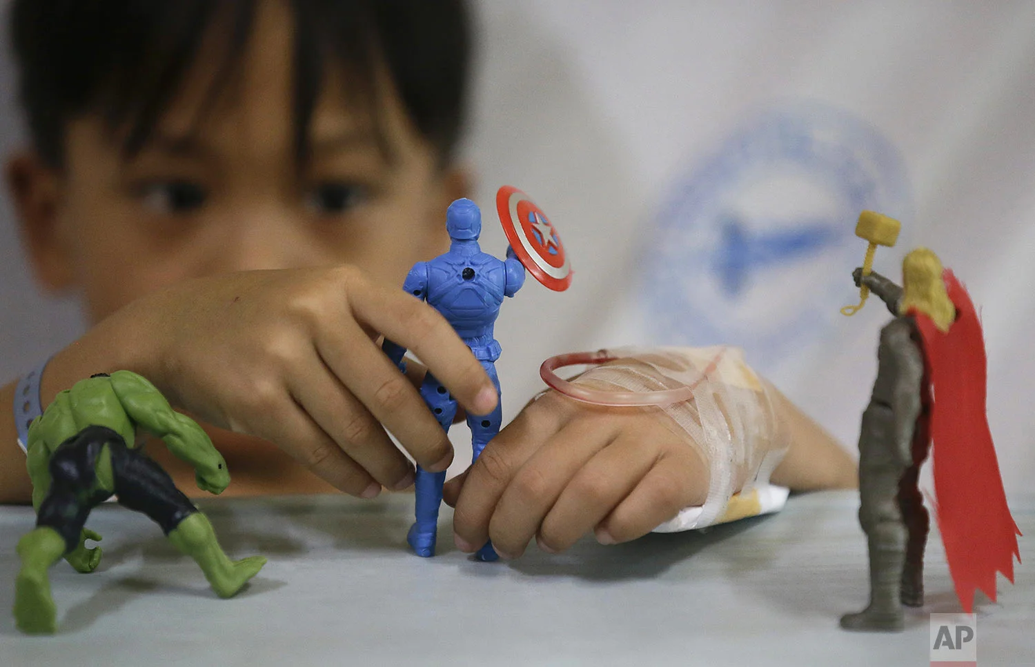 A young dengue patient plays with his action hero figurines inside his room at the San Lazaro government hospital in Manila, Philippines on Wednesday, Aug. 7, 2019. (AP Photo/Aaron Favila)