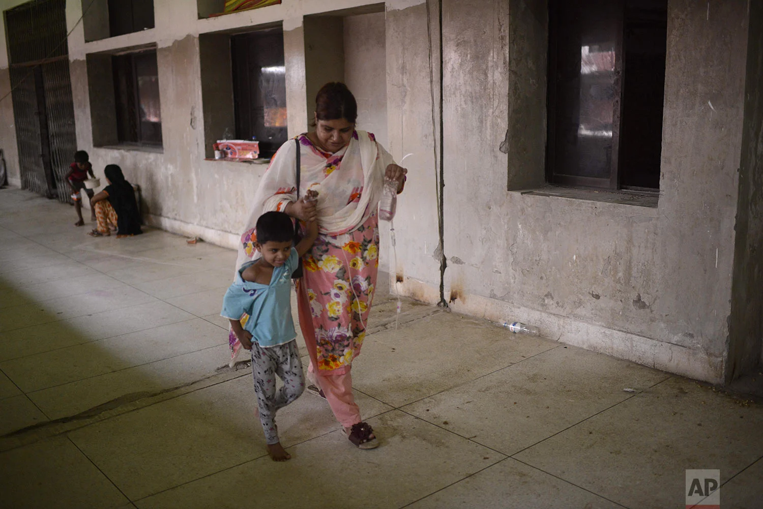 A child receiving treatment for dengue walks at Shaheed Suhrawardy Medical College and Hospital in Dhaka, Bangladesh, Wednesday, July 31, 2019. (AP Photo/Mahmud Hossain Opu)