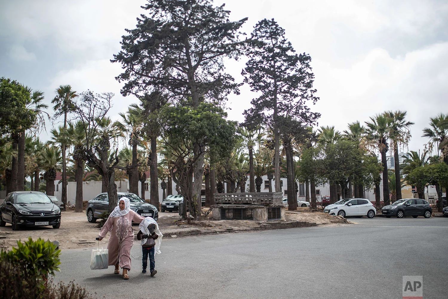 Nadia El Rami walks with her 8 year old son, Mustapha, who is affected by a rare genetic disorder called xeroderma pigmentosum, or XP, outside a hospital in Casablanca, Morocco, July 24, 2019. (AP Photo/Mosa'ab Elshamy)