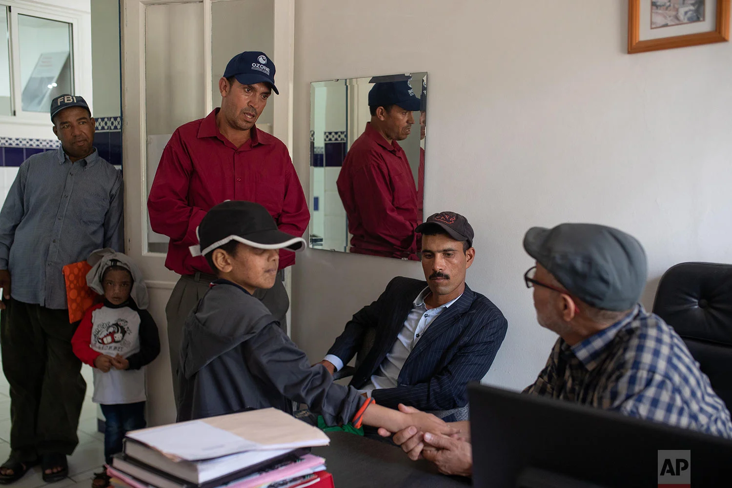 Habib El Ghazaoui, a father who runs the Association for Solidarity with Children of the Moon, speaks with parents of children affected by a rare disorder called xeroderma pigmentosum, or XP, inside a hospital in Casablanca, Morocco, July 24, 2019. (AP Photo/Mosa'ab Elshamy)
