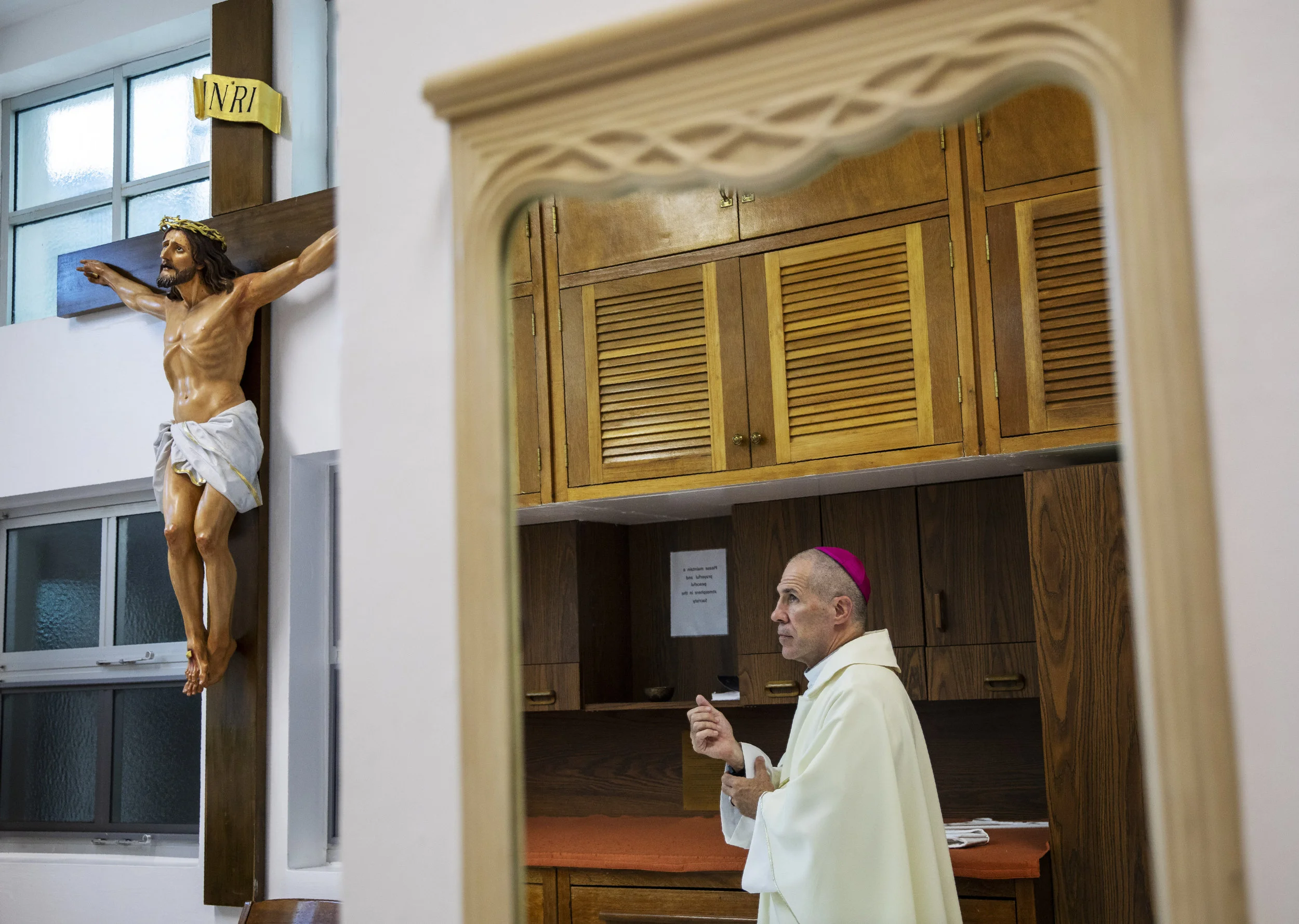 Archbishop Michael Jude Byrnes, who was sent to the island in 2016 following his predecessor's suspension, prepares to deliver Mass at Dulce Nombre de Maria Cathedral-Basilica in Hagatna, Guam, Tuesday, May 7, 2019. "It's horrific," Byrnes conceded. "The sins of the fathers are left to the children. It's important for the Church of Guam to confront, in a good way, the evil that we found, and to acknowledge it, and to own it," Byrnes said. (AP Photo/David Goldman)