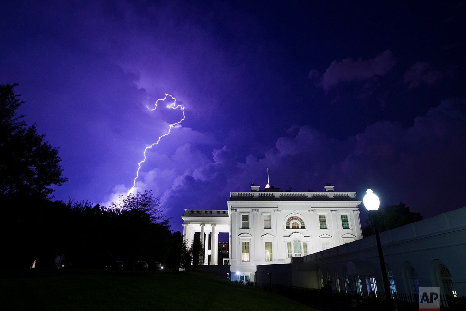  A bolt of lightning illuminates the clouds of a thunderstorm behind the White House, Tuesday, Aug. 6, 2019, in Washington. (AP Photo/Alex Brandon) 