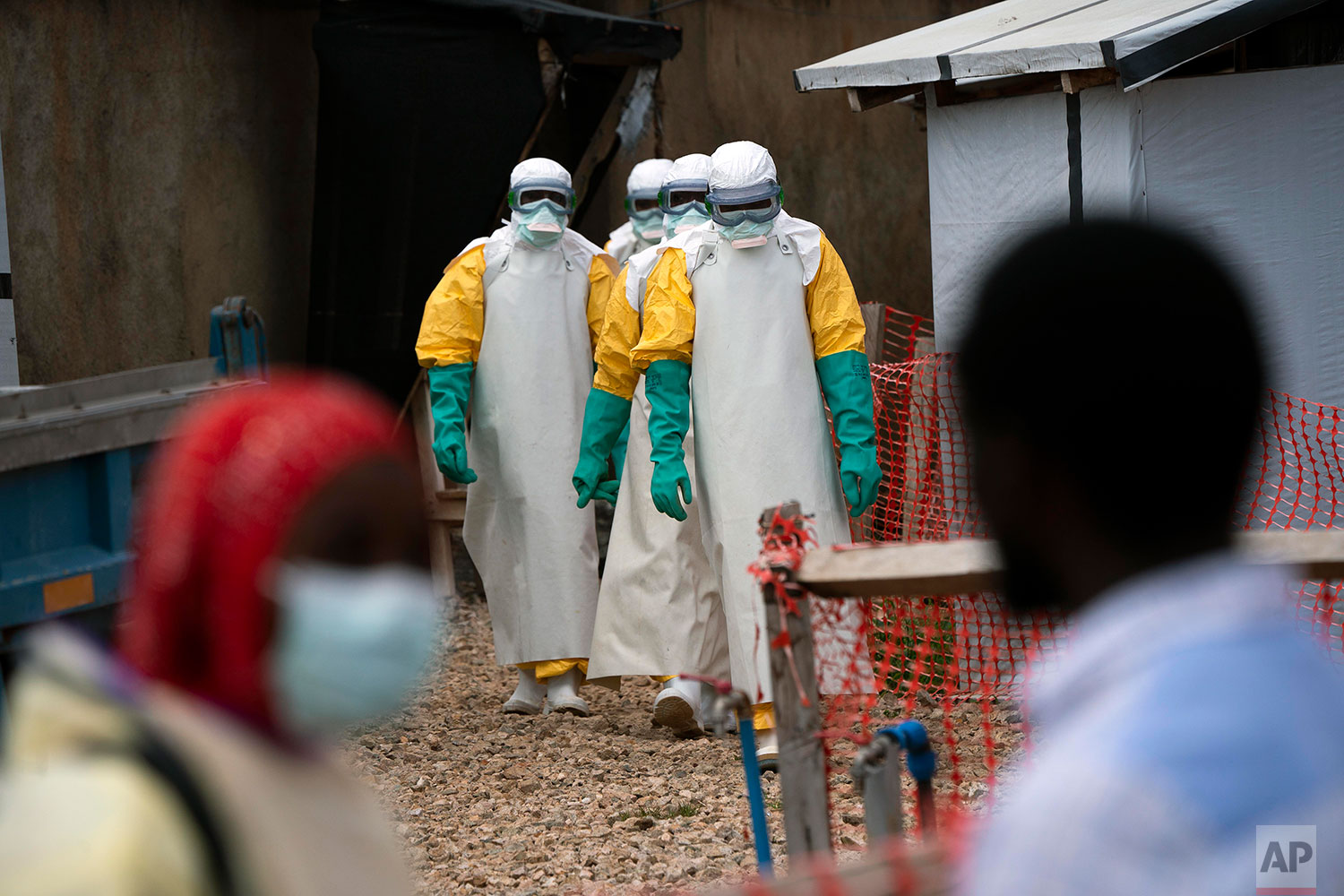 In this July 16, 2019 photo, health workers dressed in protective gear begin their shift at an Ebola treatment center in Beni, Congo DRC. (AP Photo/Jerome Delay)