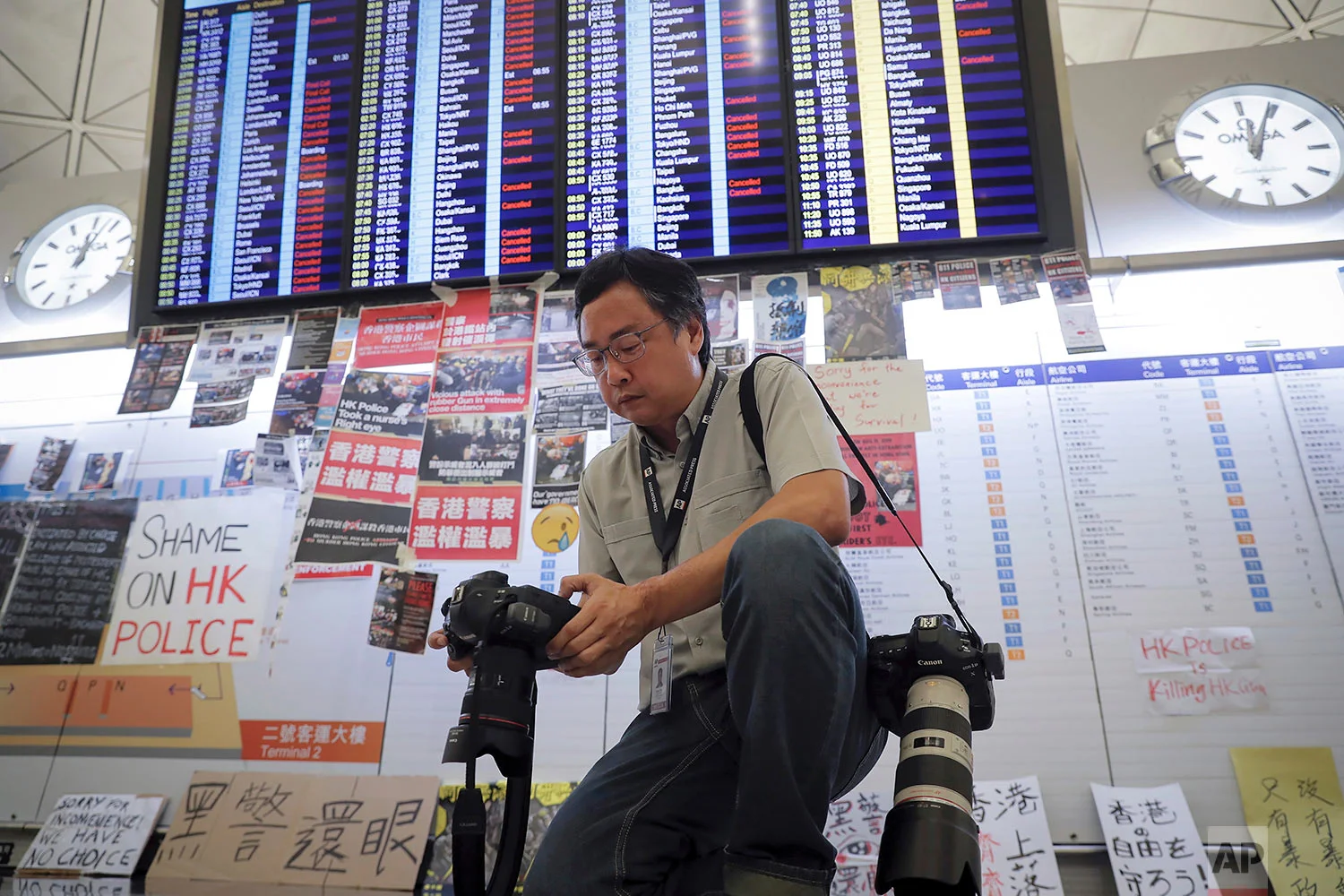 AP photographer Vincent Thian checks the images he shot at the Hong Kong International Airport in Hong Kong, Aug. 12, 2019. (AP Photo/Kin Cheung)