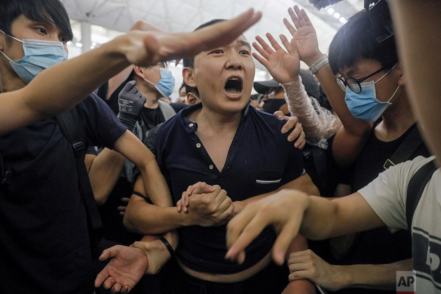 Protesters detaiN a man, who protesters claimed was a Chinese undercover agent during a demonstration at the Airport in Hong Kong, Tuesday, Aug. 13, 2019. (AP Photo/Vincent Yu)