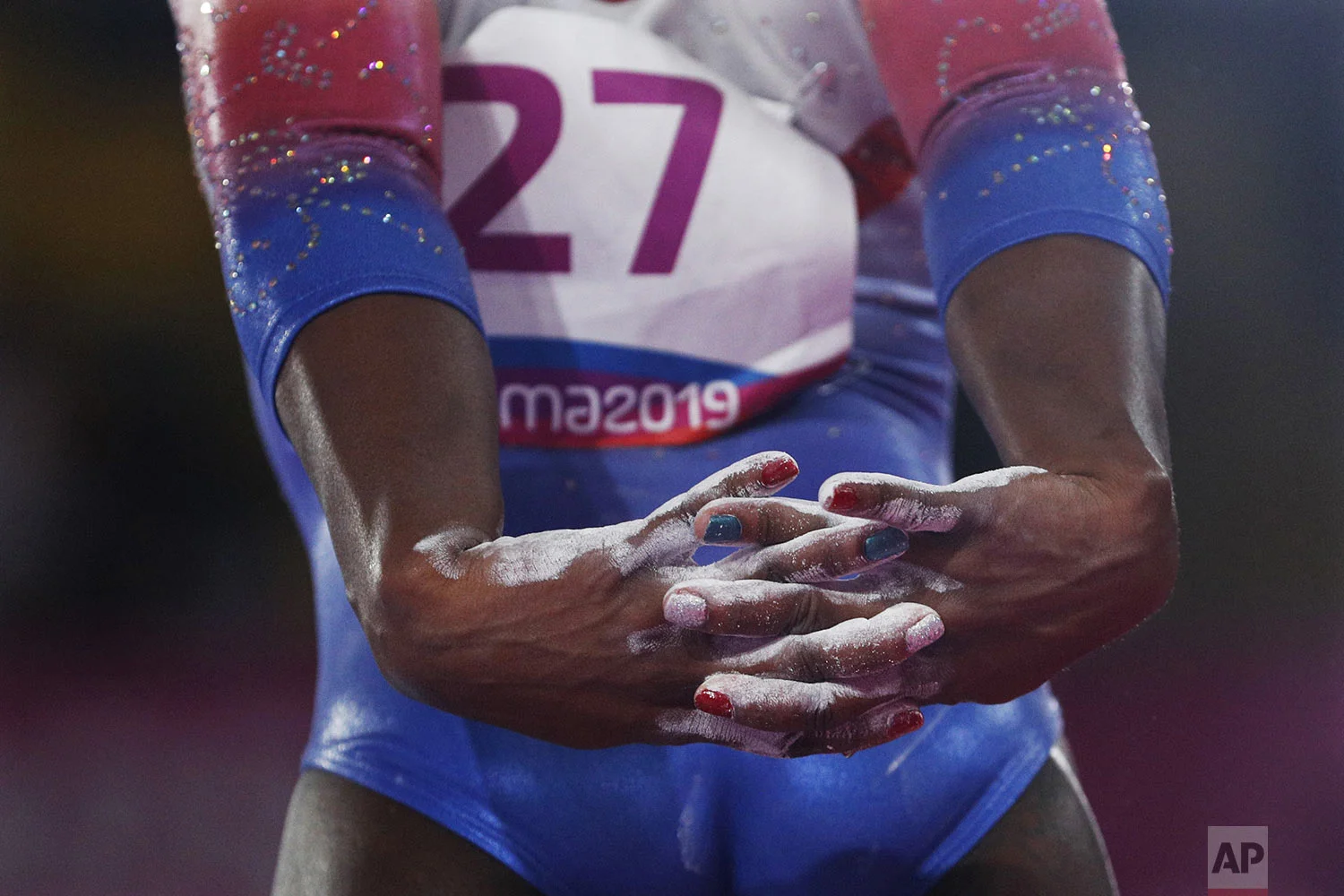 Yesenia Saskia Ferrera, of Cuba, stretches her arms behind her back as she prepares to compete on beam in the women's gymnastics qualification and team final at the Pan American Games in Lima, Peru, Saturday, July 27, 2019. (AP Photo/Rebecca Blackwell)