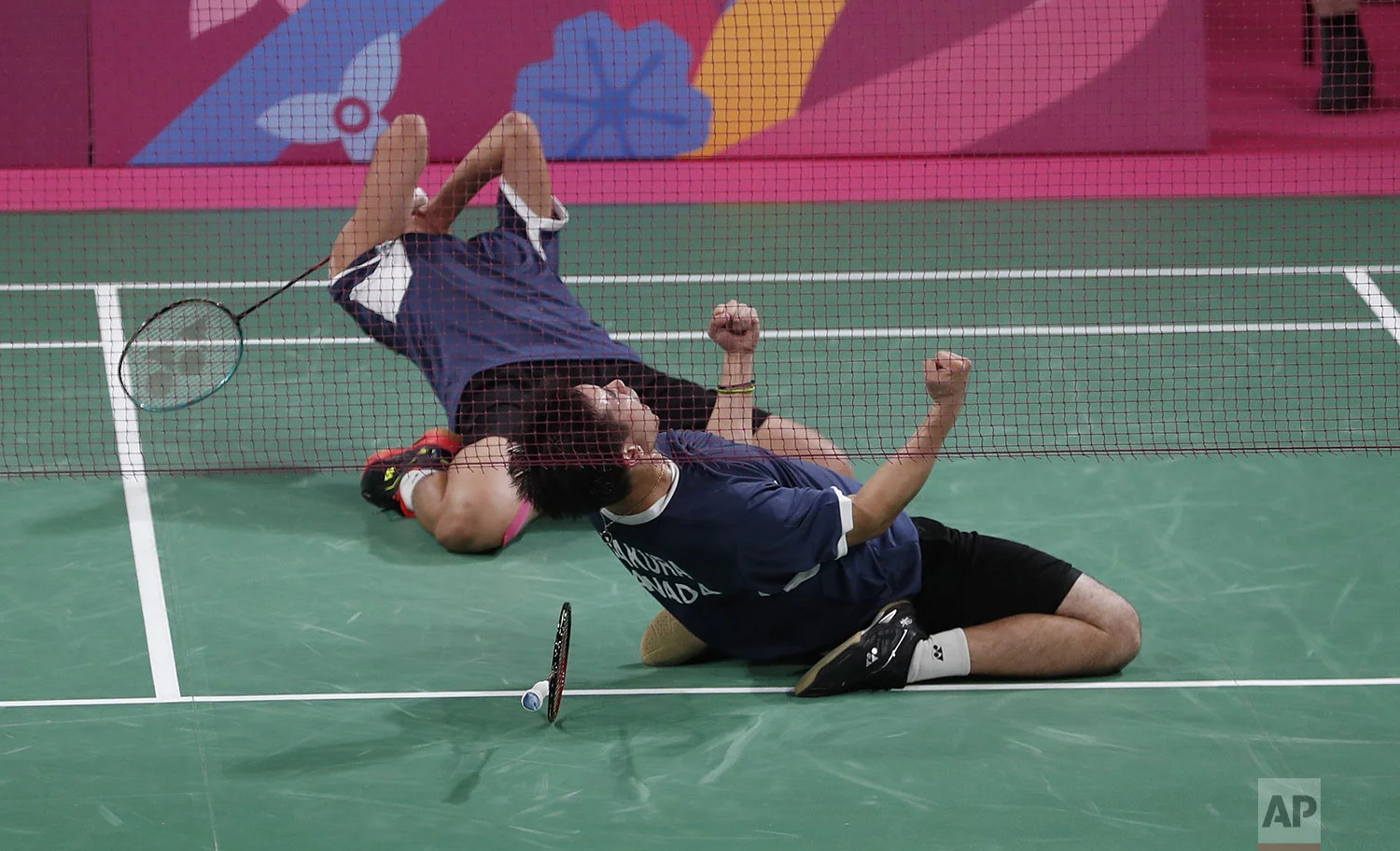Jason Ho-Shue, left, and Nyl Yakura of Canada, right, celebrate their gold medal badminton win in the men's doubles against Phillip Chew and Ryan Chew of the United States, at at the Pan American Games in Lima, Peru, Friday, Aug. 2, 2019. (AP Photo/Fernando Vergara)