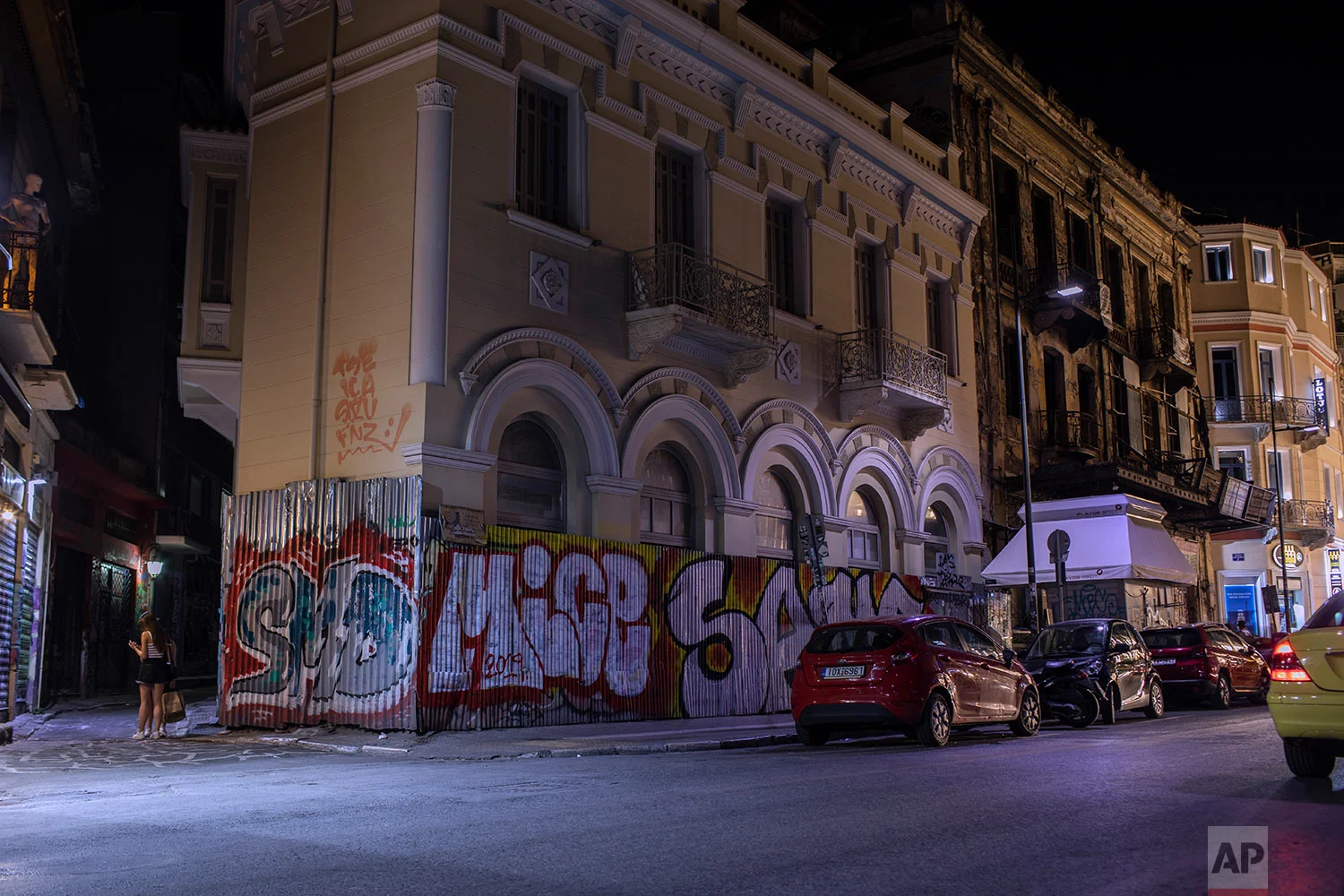 The fence of a renovated building and part of the wall are defaced with graffiti in Monastiraki district, central Athens, July 7, 2019. (AP Photo/Petros Giannakouris)