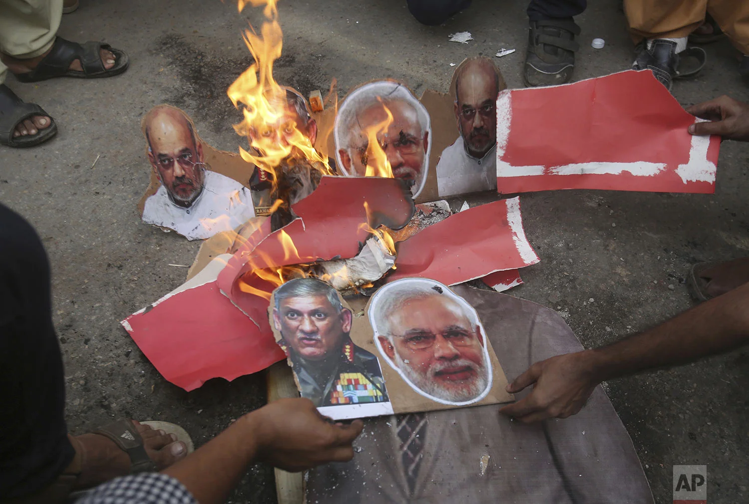 Pakistani protesters burn posters of Indian leaders during a protest in Karachi, Pakistan, Friday, Aug. 9, 2019. (AP Photo/Fareed Khan)