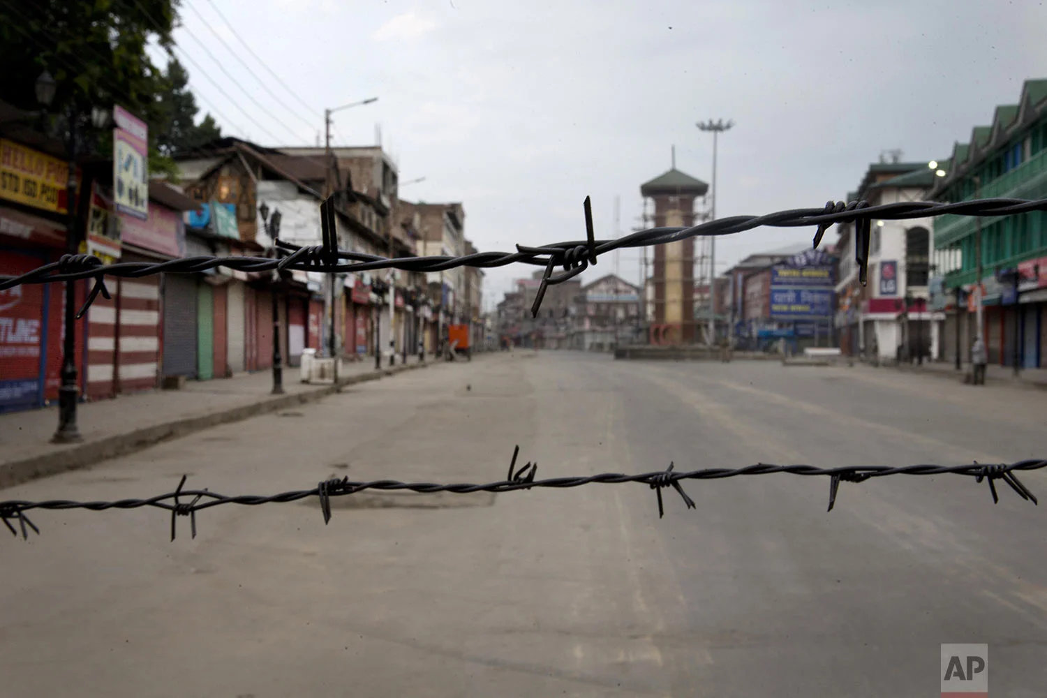 A deserted street is seen through a barbwire set up as blockade during curfew in Srinagar, Indian controlled Kashmir, Tuesday, Aug. 6, 2019. (AP Photo/Dar Yasin)
