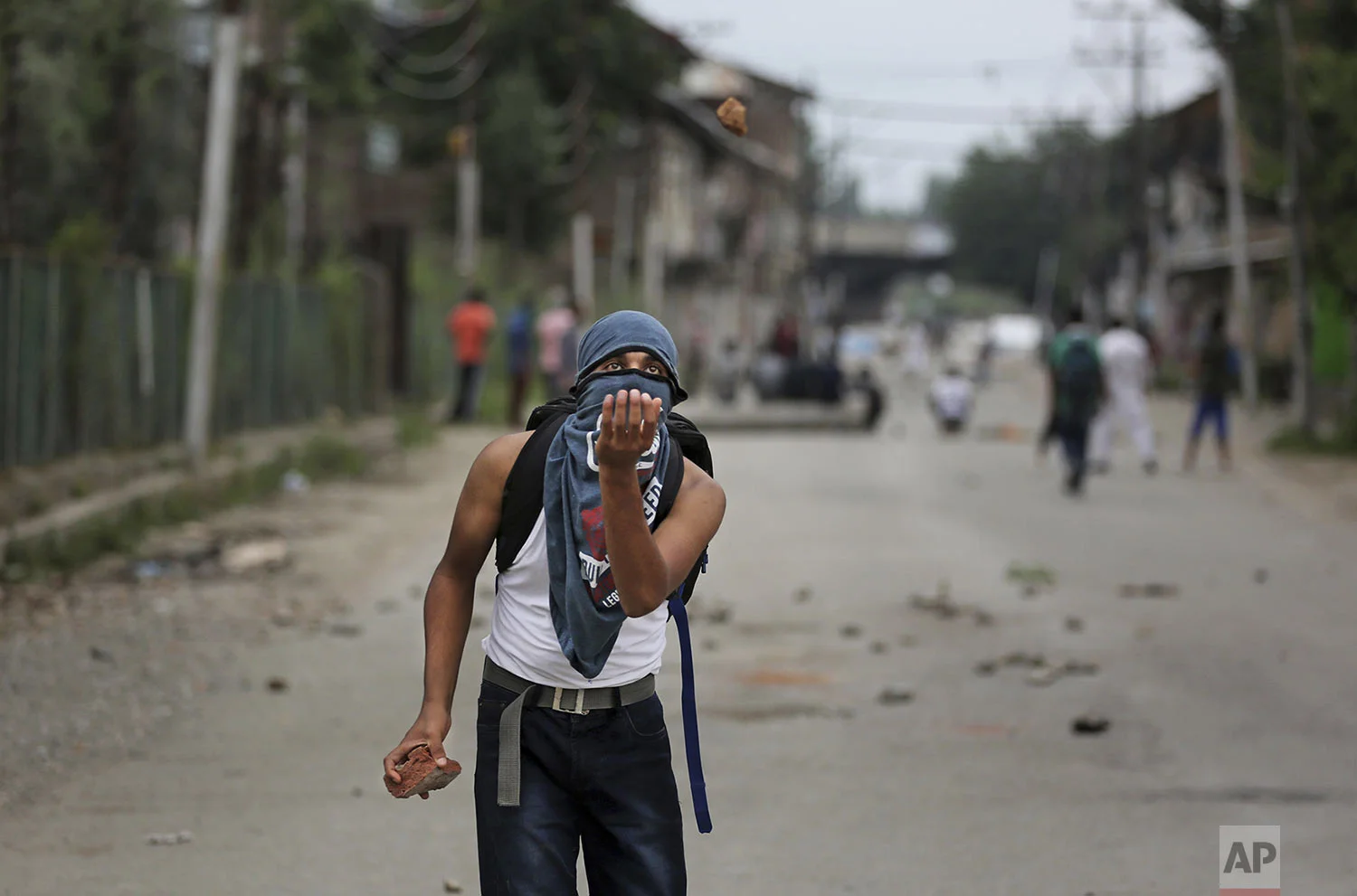 A Kashmiri prepares to catch a stone during an anti-India protest Srinagar, India, Friday, Aug. 9, 2019. The predominantly Muslim area has been under an unprecedented security lockdown and near-total communications blackout to prevent unrest and protests after India's Hindu nationalist-led government said Monday it was revoking Kashmir’s special constitutional status and downgrading its statehood. (AP Photo/Altaf Qadri)