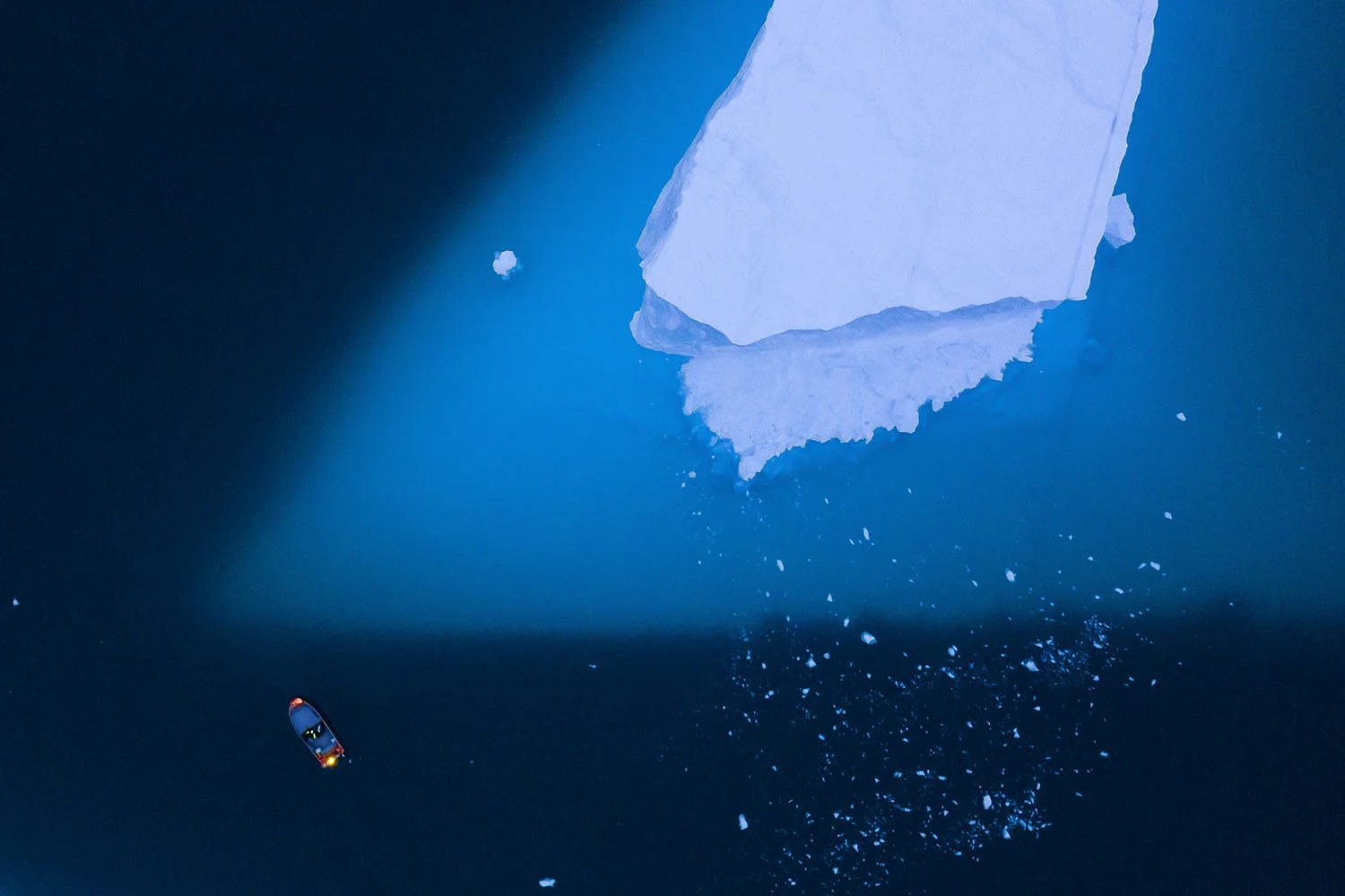 A boat navigates next to a large iceberg in on Aug. 15, 2019, in eastern Greenland. Greenland's ice has been melting for more than 20 years, but in 2019, it's as if Earth's refrigerator door has been left open, and it means a potentially large rise in the world's sea levels. (AP Photo/Felipe Dana)