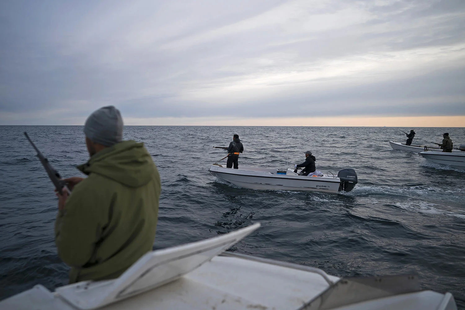 Mugu Utuaq, left, reloads his rifle as he rides with other boats hunting whales on Aug. 16, 2019, near Kulusuk, Greenland. Summer in 2019 is hitting the island hard with record-shattering heat and extreme melt. Scientists estimate that by the end of the summer, about 440 billion tons of ice, maybe more, will have melted or calved off Greenland's giant ice sheet. (AP Photo/Felipe Dana)
