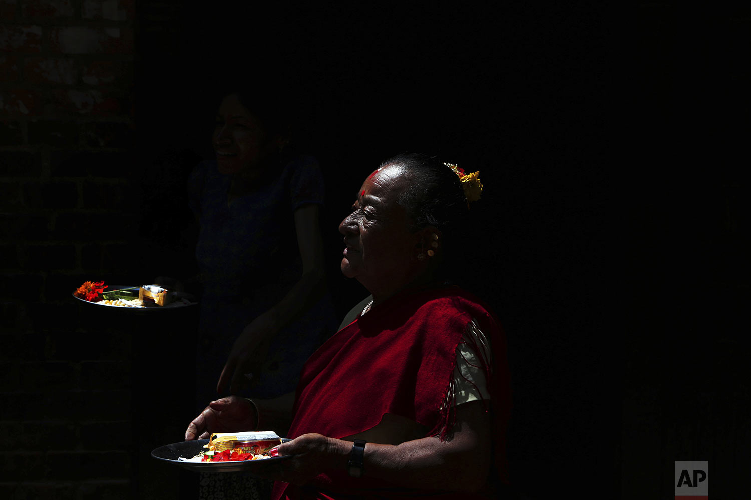  A Nepalese woman waits to worship a Buddha idol that is paraded during the Pancha Dan festival in Bhaktapur, Nepal, Wednesday, Aug. 28, 2019. (AP Photo/Niranjan Shrestha) 