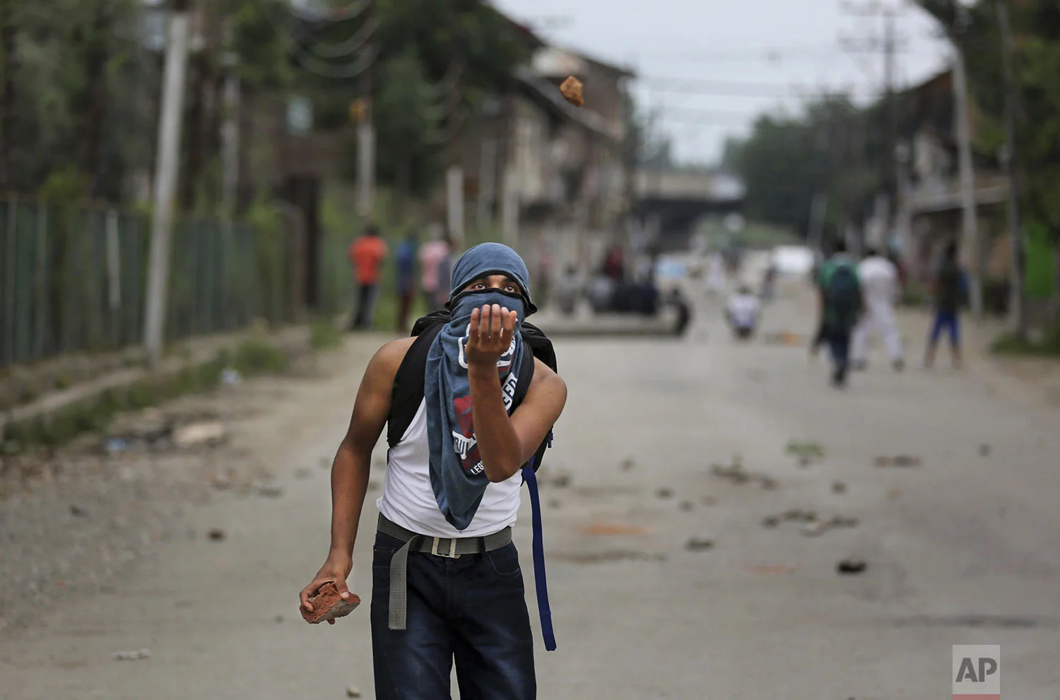 A Kashmiri prepares to catch a stone during an anti-India protest Srinagar, India, Friday, Aug. 9, 2019 (AP Photo/Altaf Qadri)