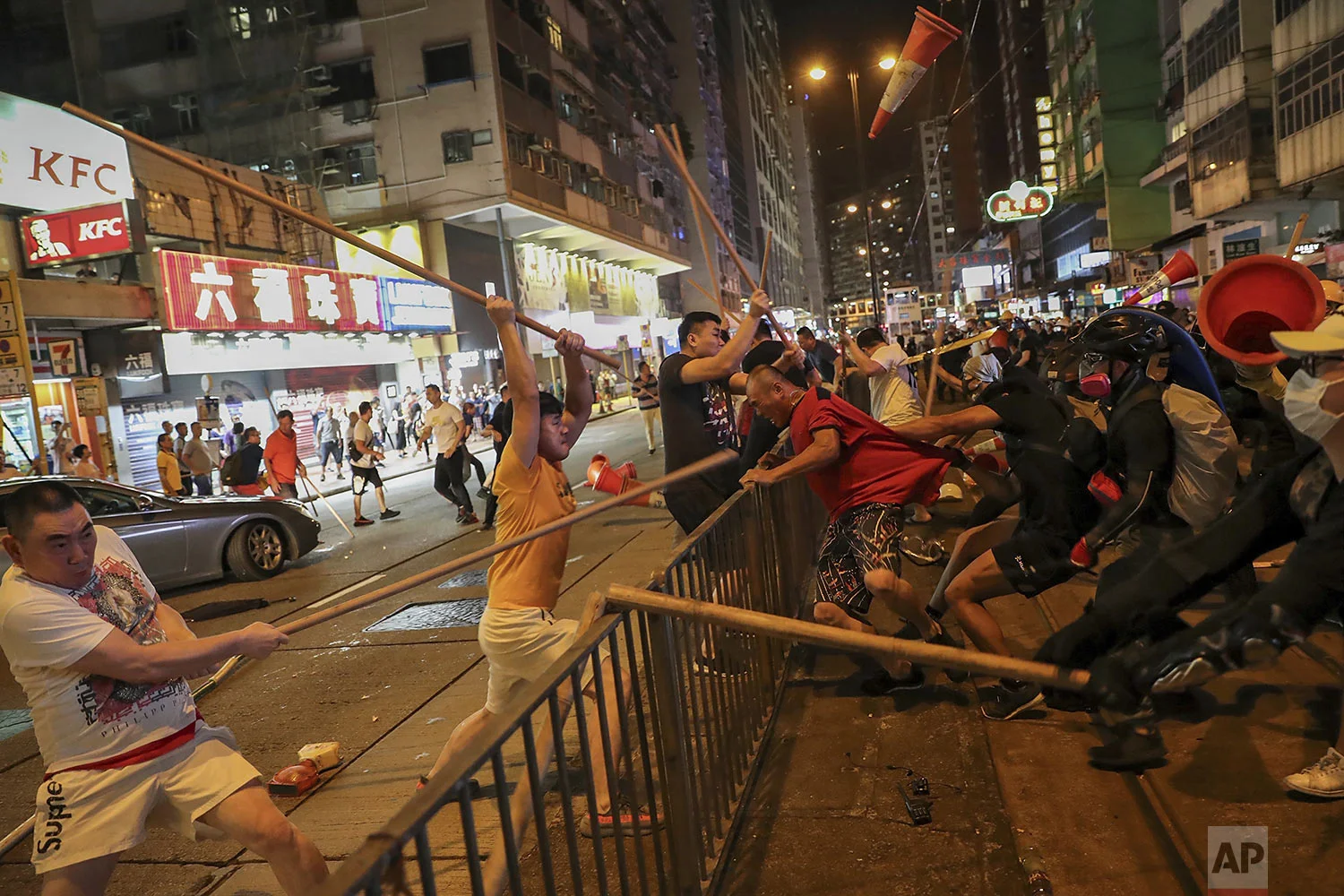 Protesters wearing black shirts, right, fight with a group of men wielding wooden poles on a street during the anti-extradition bill protest at a neighborhood in Hong Kong, Monday, Aug. 5, 2019. (AP Photo)