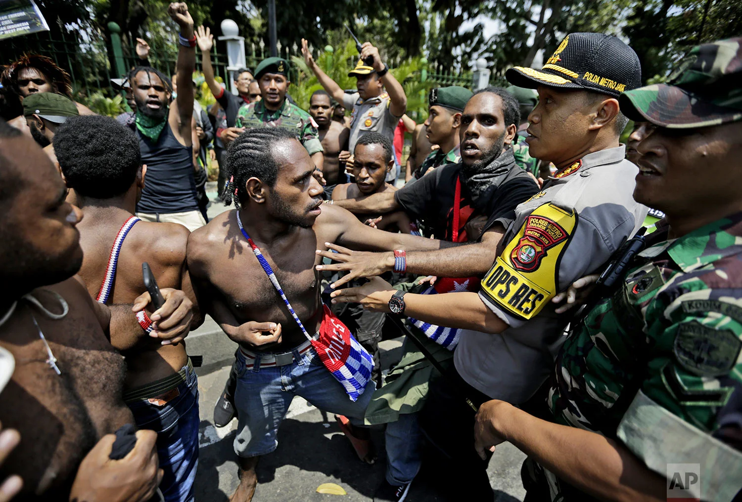 Papuan activists scuffle with police and soldiers during a rally near the presidential palace in Jakarta, Indonesia, Thursday, Aug. 22, 2019. (AP Photo/Dita Alangkara)