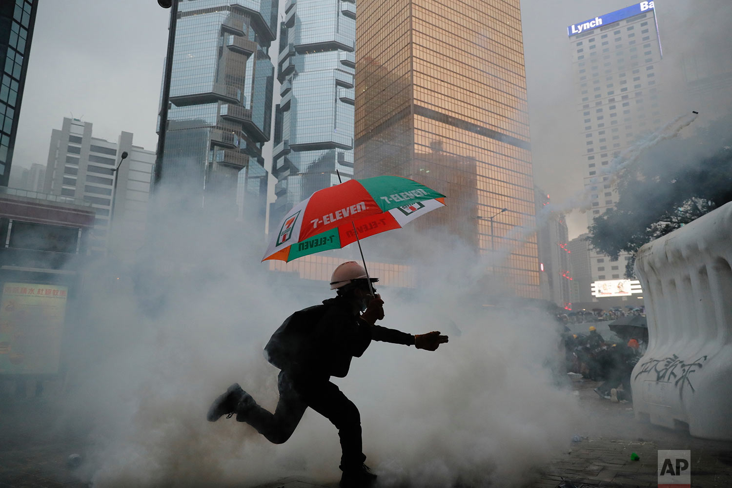 A protestor throws back an exploded tear gas shell at police officers in Hong Kong, Saturday, Aug. 31, 2019. Tear gas, pepper spray and fire returned to the streets of Hong Kong, as police officers clashed with masked pro-democracy protesters in the first notable display of unrest since Hong Kong’s top leader announced that she would withdraw a deeply unpopular extradition bill. (AP Photo/Kin Cheung)
