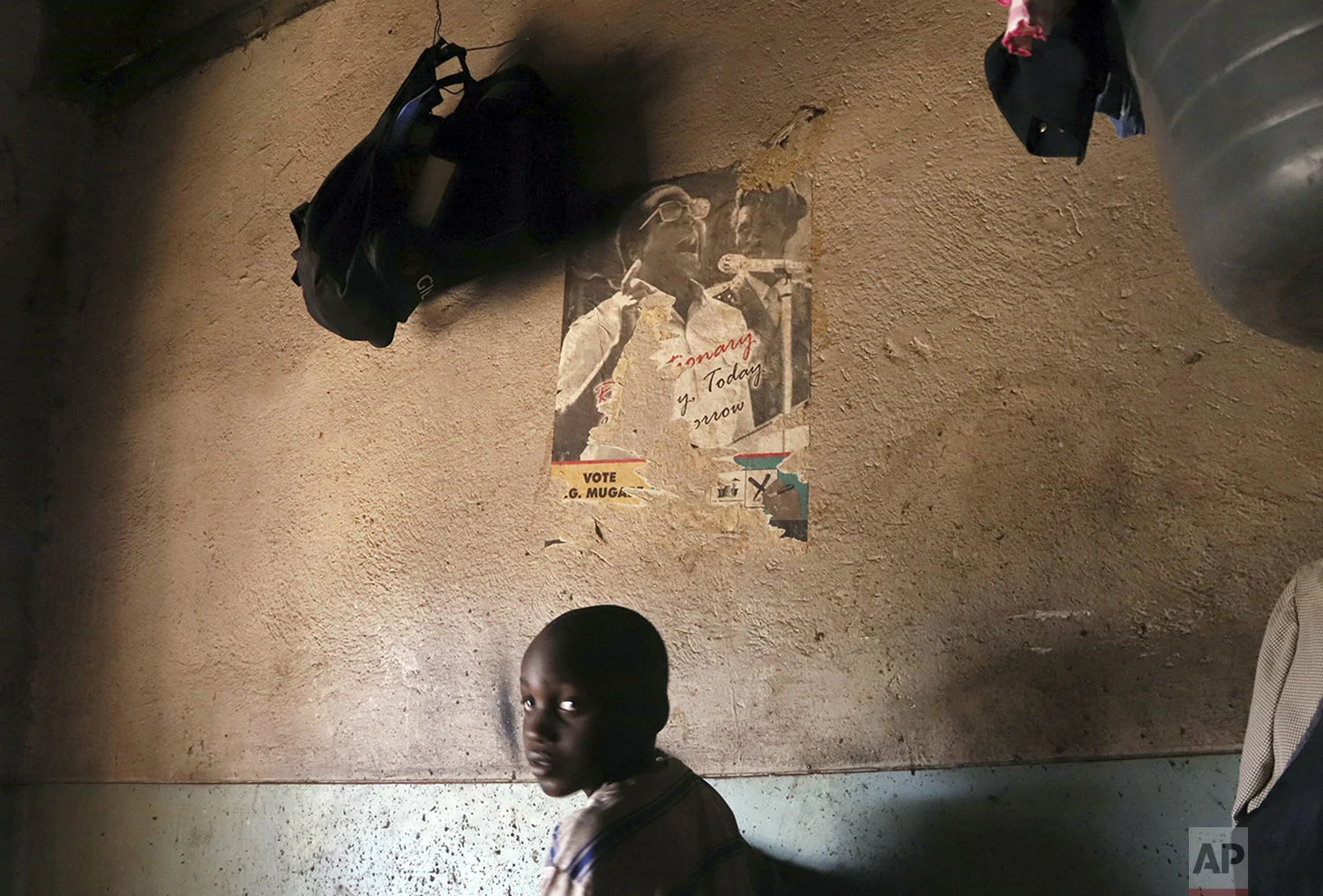 A young child passes by an old torn poster of former Zimbabwean President Robert Mugabe in a building in Harare Friday, Sept. 6, 2019. Mugabe, the former leader of Zimbabwe forced to resign in 2017 after a 37-year rule whose early promise was eroded by economic turmoil, disputed elections and human rights violations, has died. He was 95. (AP Photo)