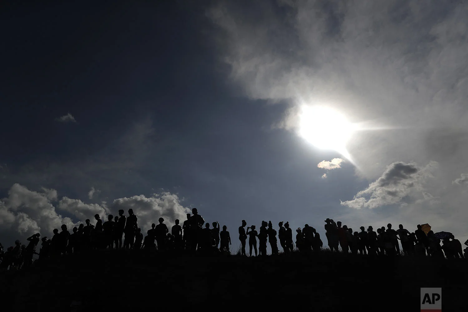 People painted with black grease gather on top of a hill as they take part in the traditional festivities of the Cascamorras festival in Baza, Spain, Friday, Sept. 6, 2019. (AP Photo/Manu Fernandez)