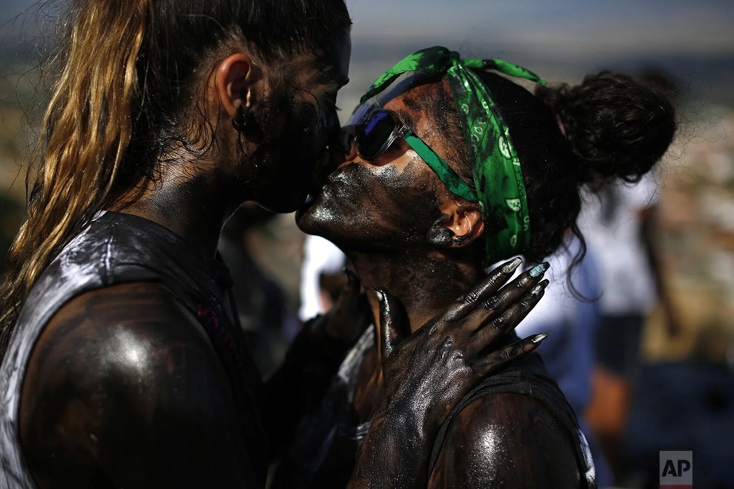 A couple painted with black grease kiss each other as they take part at the traditional festivities of the Cascamorras festival in Baza, Spain, Friday, Sept. 6, 2019. (AP Photo/Manu Fernandez)