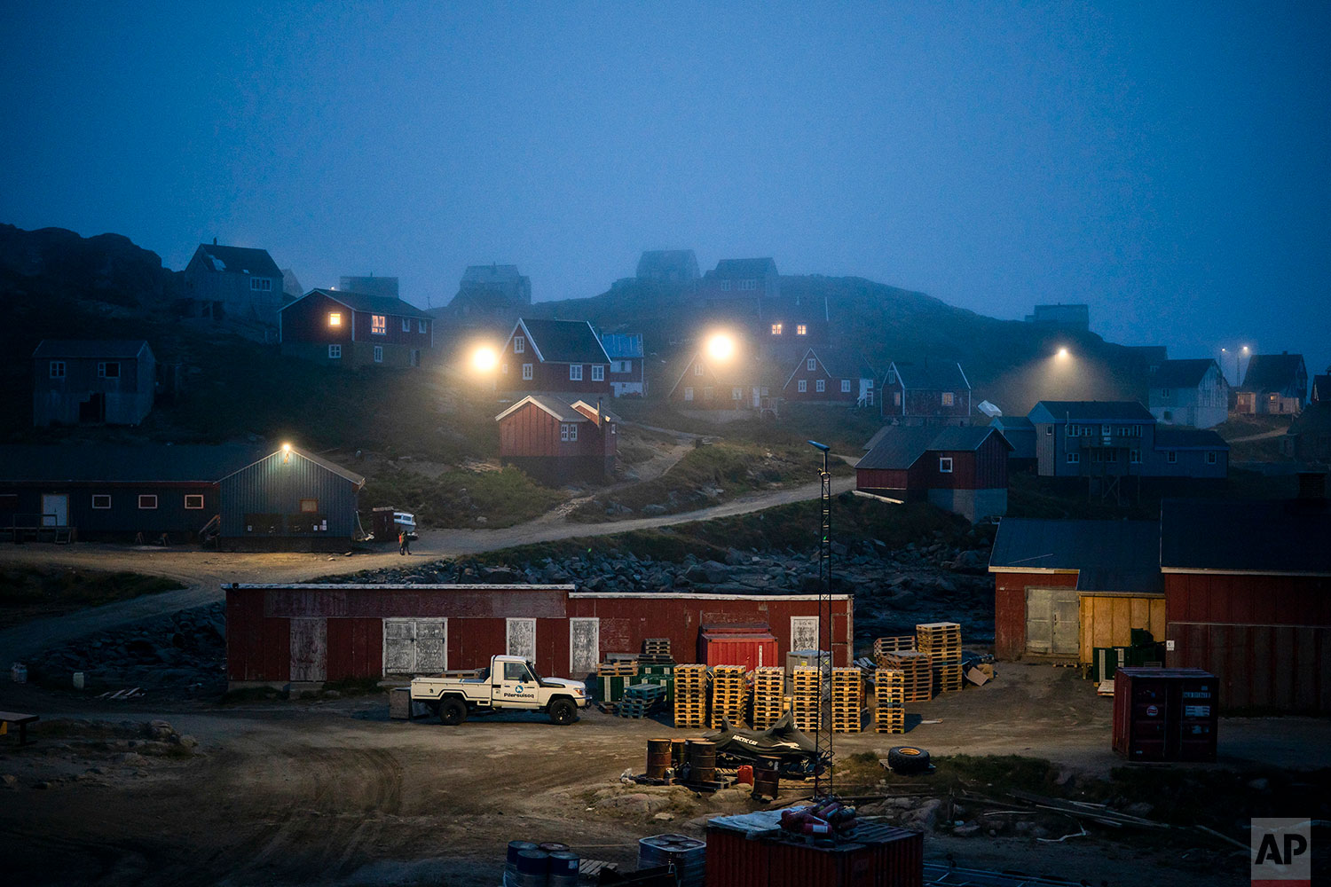 In this Aug. 15, 2019 photo, homes are partly covered by early morning fog in Kulusuk, Greenland. (AP Photo/Felipe Dana)