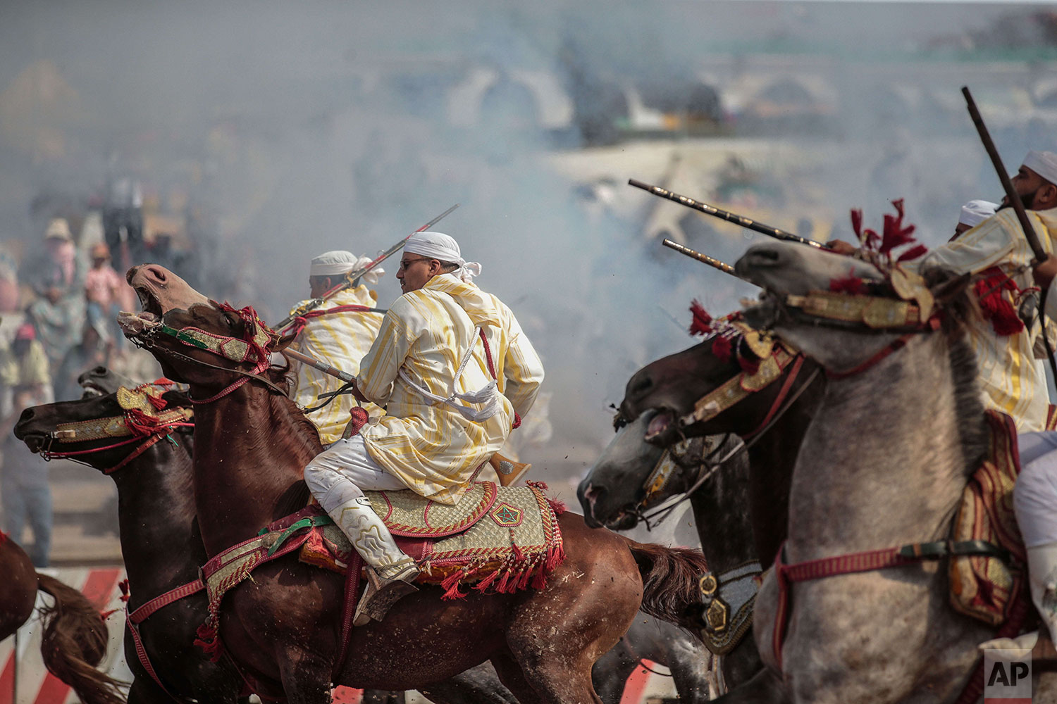 In this Thursday, July 25, 2019 photo, a troupe charges and fire their rifles during Tabourida, a traditional horse riding show also known as Fantasia, in the coastal town of El Jadida, Morocco. (AP Photo/Mosa'ab Elshamy)