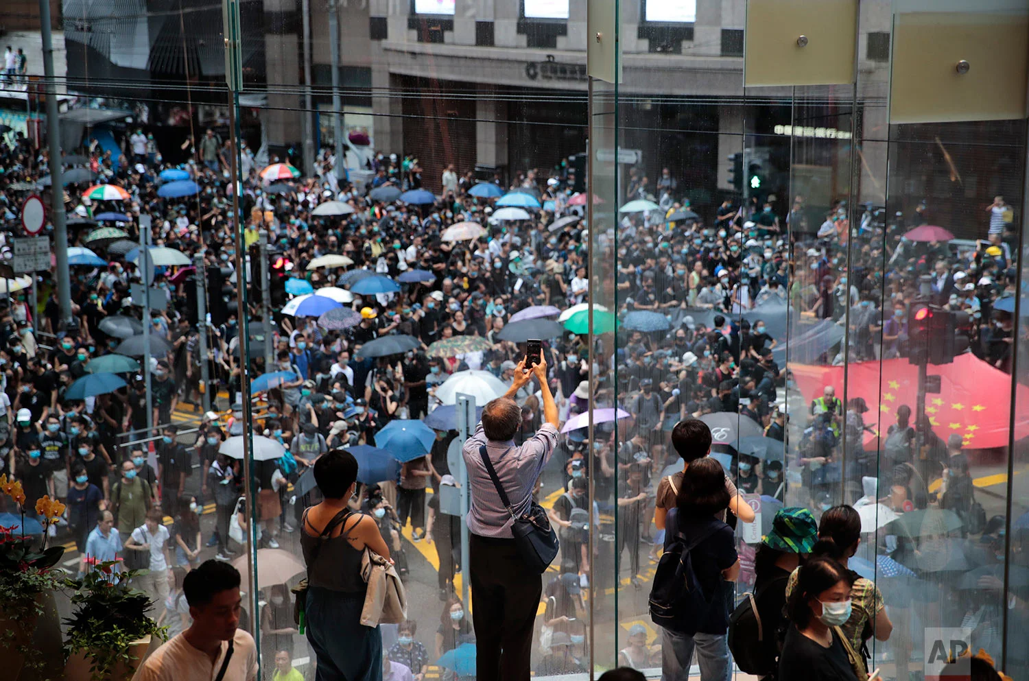 Spectators watch as pro-democracy protesters march in central Hong Kong, Aug. 31, 2019. (AP Photo/Jae C. Hong)