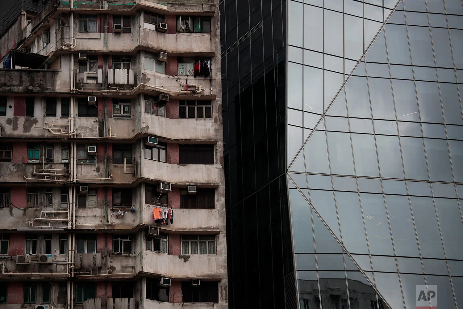 An old apartment building stands next to a gleaming tower in Hong Kong, Sept. 1, 2019. (AP Photo/Jae C. Hong)
