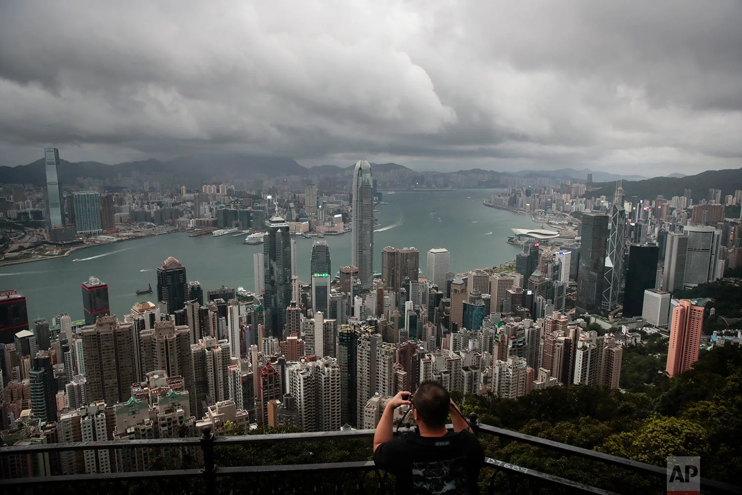 A man sets up his camera in the Victoria Peak area to photograph Hong Kong's skyline, Sept. 1, 2019. (AP Photo/Jae C. Hong)