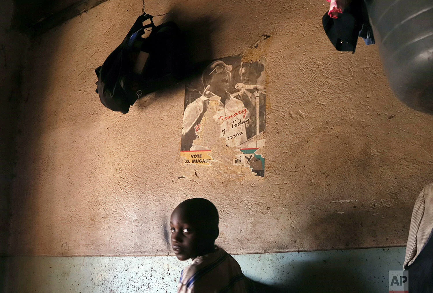 A young child walks past a poster of former Zimbabwean President Robert Mugabe in a building in Harare, Sept. 6, 2019. (AP Photo)