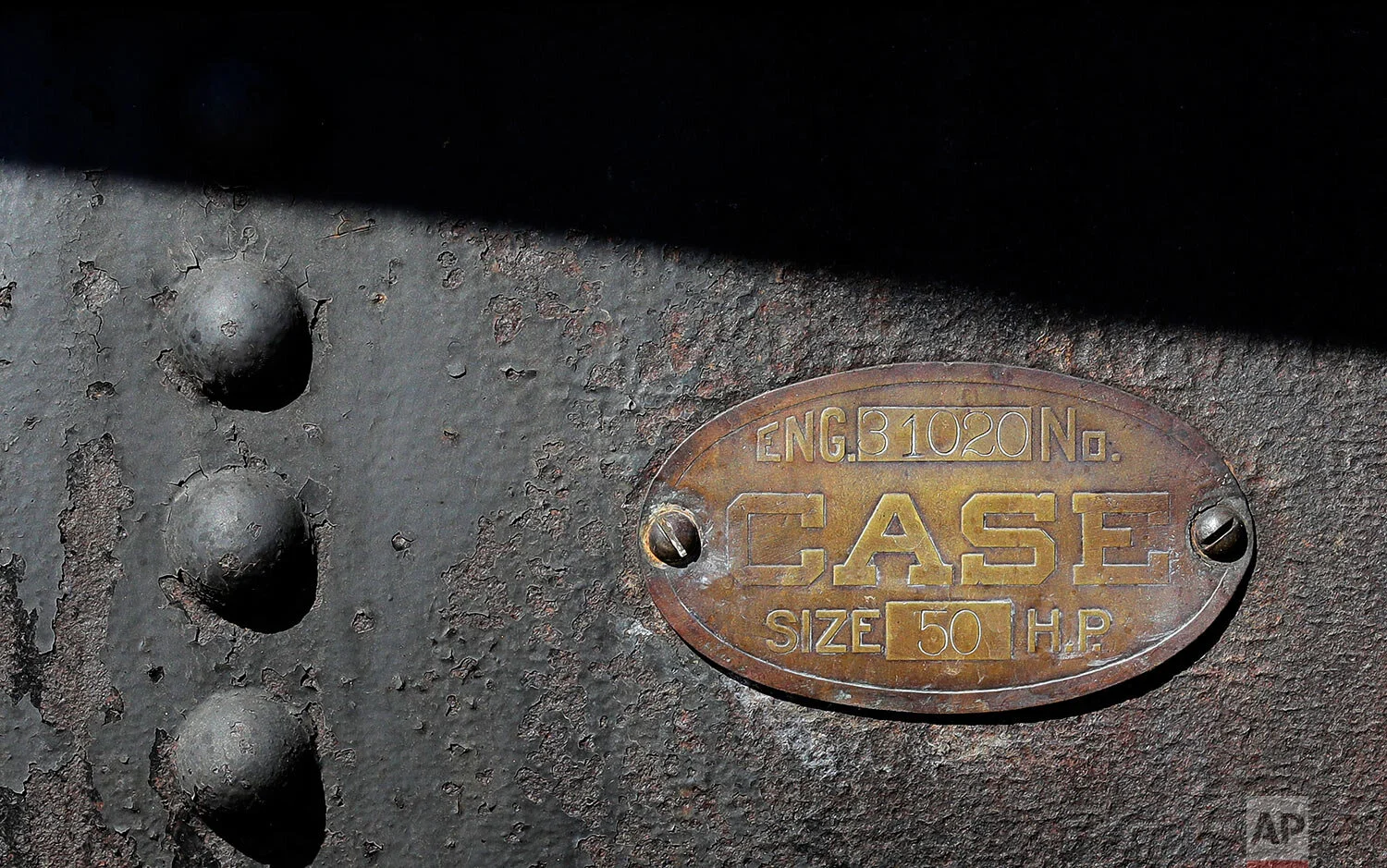 An identification plate on a 100-year-old Case steam traction engine indicates its power capacity at 50 horsepower as the machine is used to drive a stationary grain thresher near Colfax, Wash., Sept. 2, 2019. (AP Photo/Ted S. Warren)