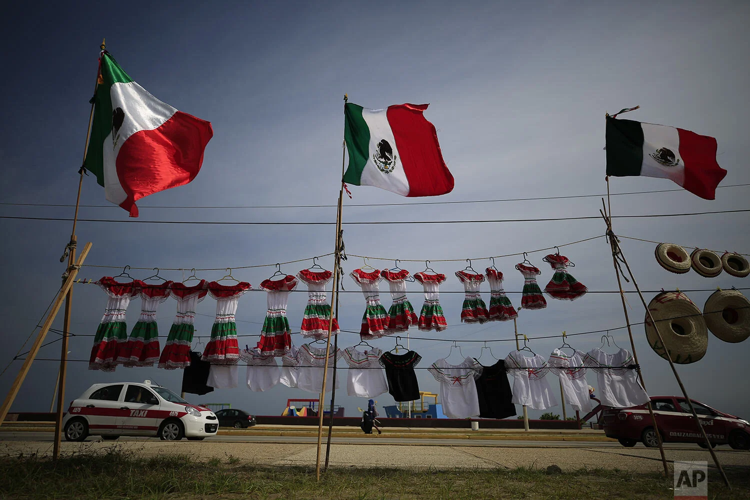 A vendor sells Mexican flags and items in the flag's colors ahead of upcoming Independence Day celebrations, in Coatzacoalcos, Veracruz state, Mexico, Aug. 30, 2019. Mexico's drug war appears to be back, and it may be worse this time around than in the bloody years of the government's 2006-2012 offensive against drug cartels. That was evident this week in Coatzacoalcos, an oil industry city in the Gulf coast state of Veracruz where residents say gangs have been fighting over turf and extorting business owners with threats of violence. (AP Photo/Rebecca Blackwell)