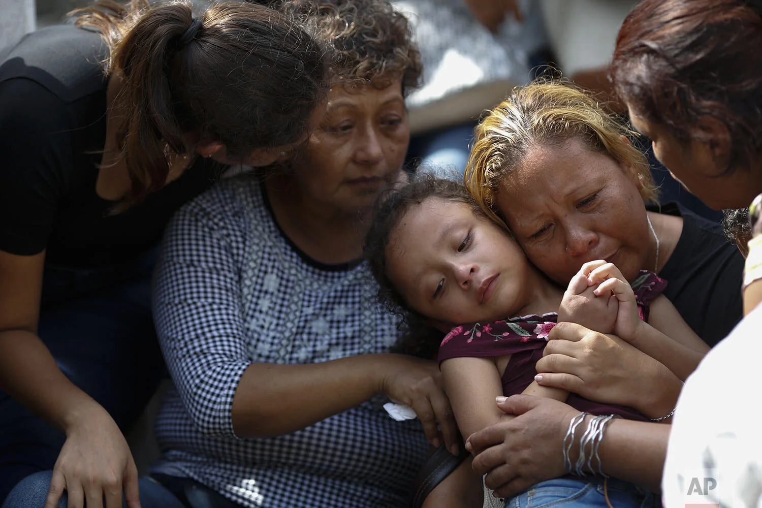 Vanessa Galindo Blas, second right, embraces one of the couple's three children, as family members comfort each other during the burial of her husband Erick Hernandez Enriquez, also known as DJ Bengala, who was killed in an attack on the White Horse nightclub where he was DJ'ing, at the municipal cemetery in Coatzacoalcos, Veracruz state, Mexico, Aug. 29, 2019. At least seven of the more than two dozen victims were laid to rest in the municipal cemetery Thursday afternoon, in overlapping burials two days after gang members blocked the club's exits and set it on fire.(AP Photo/Rebecca Blackwell)