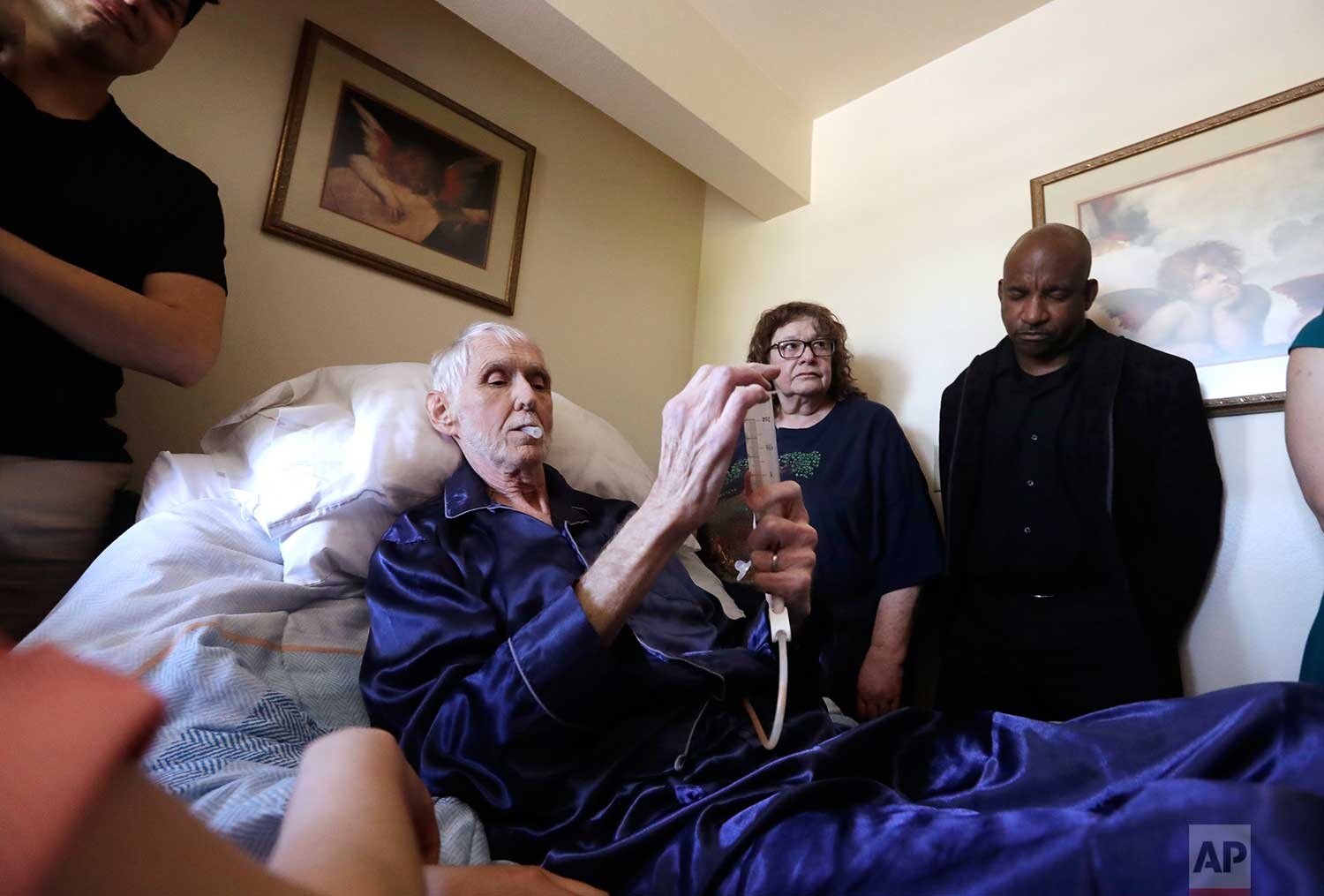  In this May 10, 2019, photo, Robert Fuller begins to plunge the drugs that will end his life into his feeding tube in Seattle. (AP Photo/Elaine Thompson) 