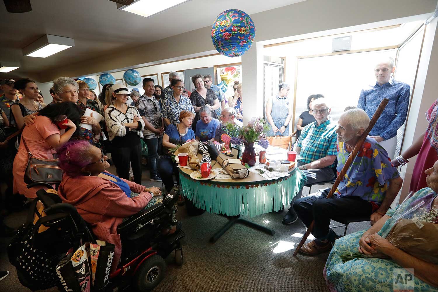  In this May 10, 2019, photo, Robert Fuller, seated right, turns toward a woman who began sobbing as Fuller announced to the group that he would be leaving shortly for his apartment to die, in Seattle. "I'm so ready to go," he said to her. "I'm tired