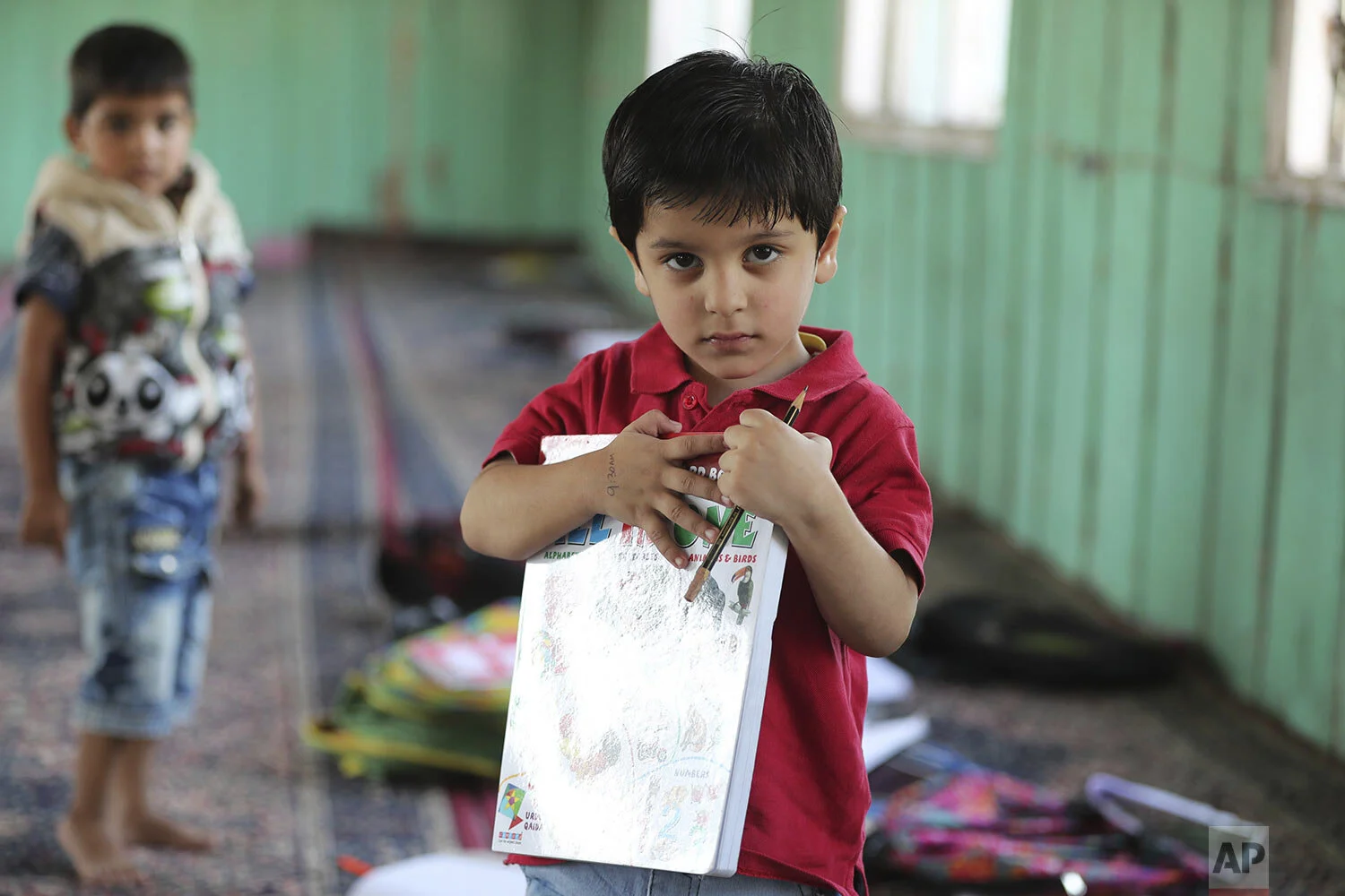 Children study inside a local mosque during a free classe by locals in Srinagar, Indian controlled Kashmir, Thursday, Sept. 19, 2019. (AP Photo/Mukhtar Khan)