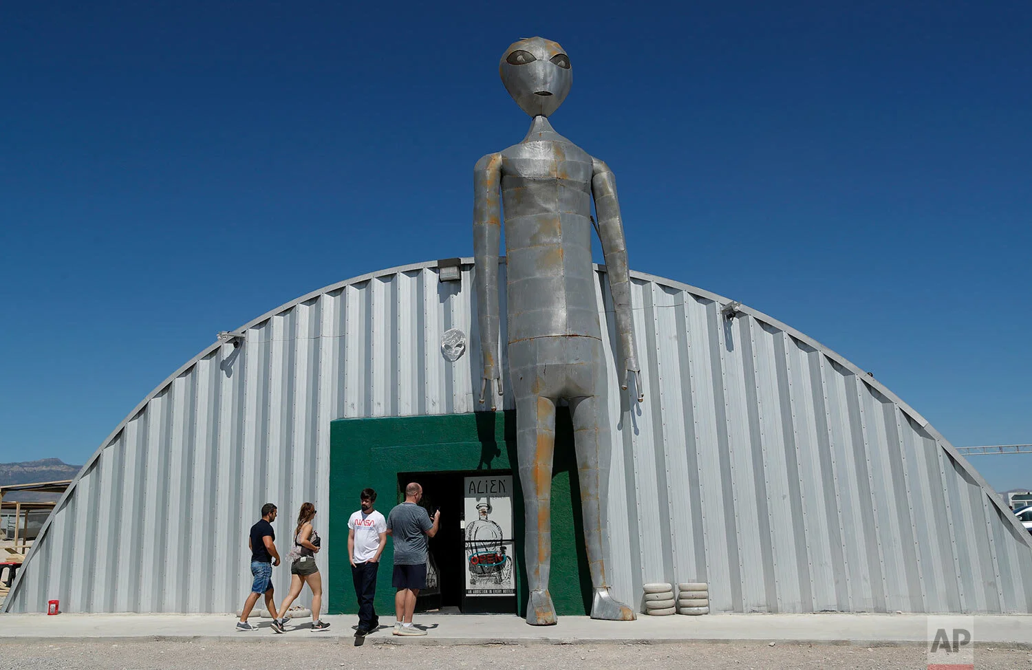 People enter and exit the Alien Research Center in Hiko, Nev. No one knows what to expect, but lots of people are preparing for "Storm Area 51" on Wednesday, Sept. 18, 2019, in the Nevada desert. (AP Photo/John Locher)