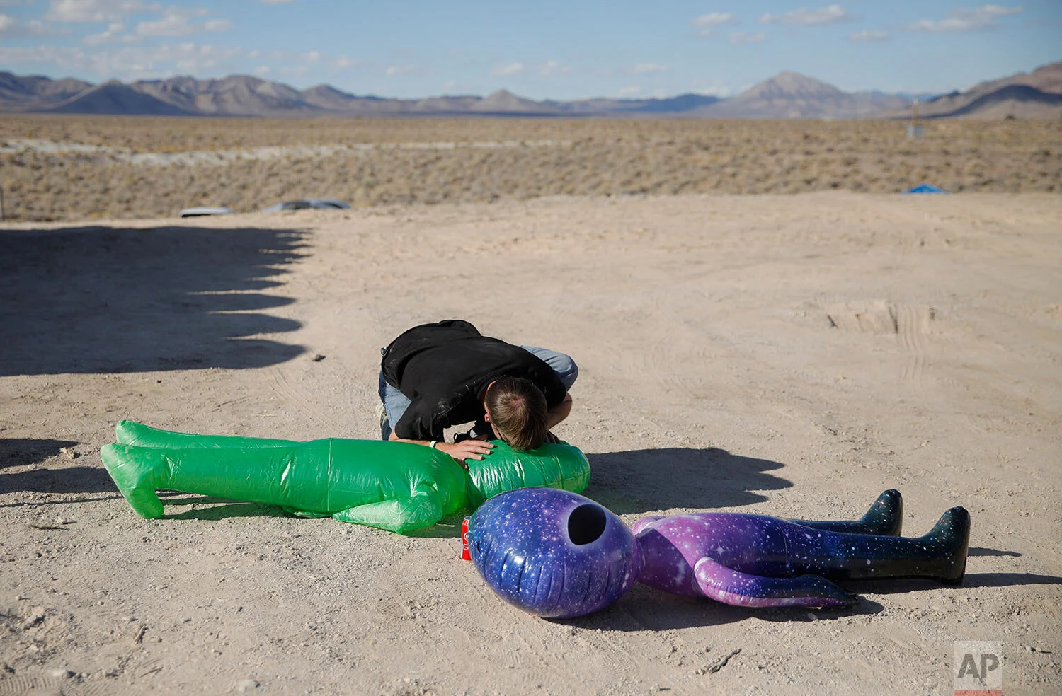 Marshall Bishop blows up an inflatable alien at the Storm Area 51 Basecamp event Friday, Sept. 20, 2019, in Hiko, Nev. "It's the perfect stat to have this in. They turn everything into a party," Bishop said about the event, which was inspired by the "Storm Area 51" internet hoax. (AP Photo/John Locher)