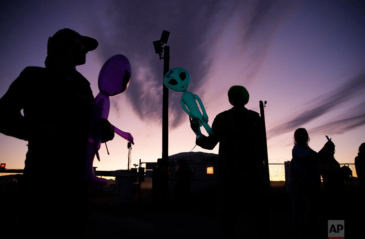Joel Kelsey, left, and Chase Hansen hold inflatable aliens near an entrance to the Nevada Test and Training Range near Area 51, Friday, Sept. 20, 2019, near Rachel, Nev. (AP Photo/John Locher)
