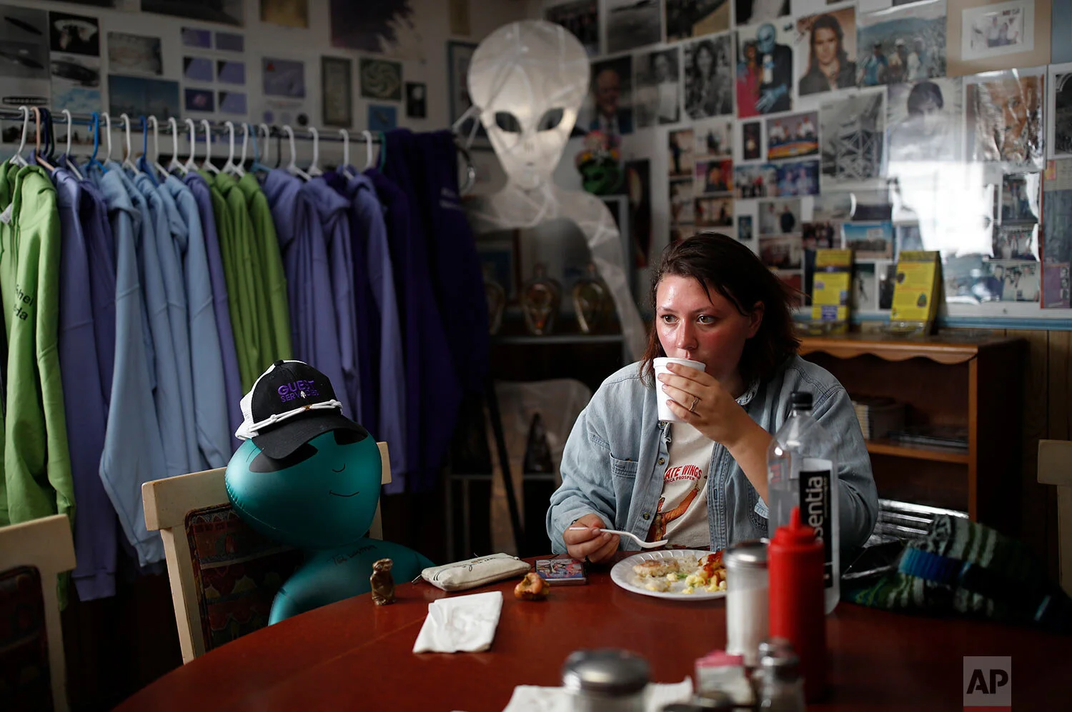 Michaela Ripley eats breakfast beside her inflatable alien the Little A'Le'Inn during an event inspired by the "Storm Area 51" internet hoax Saturday, Sept. 21, 2019, in Rachel, Nev. (AP Photo/John Locher)