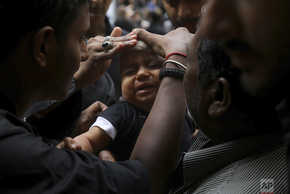 A Shiite Muslim child cries after he was given a cut on the forehead during an Ashoura procession in Hyderabad, India, Tuesday, Sept. 10, 2019. (AP Photo/Mahesh Kumar A.)