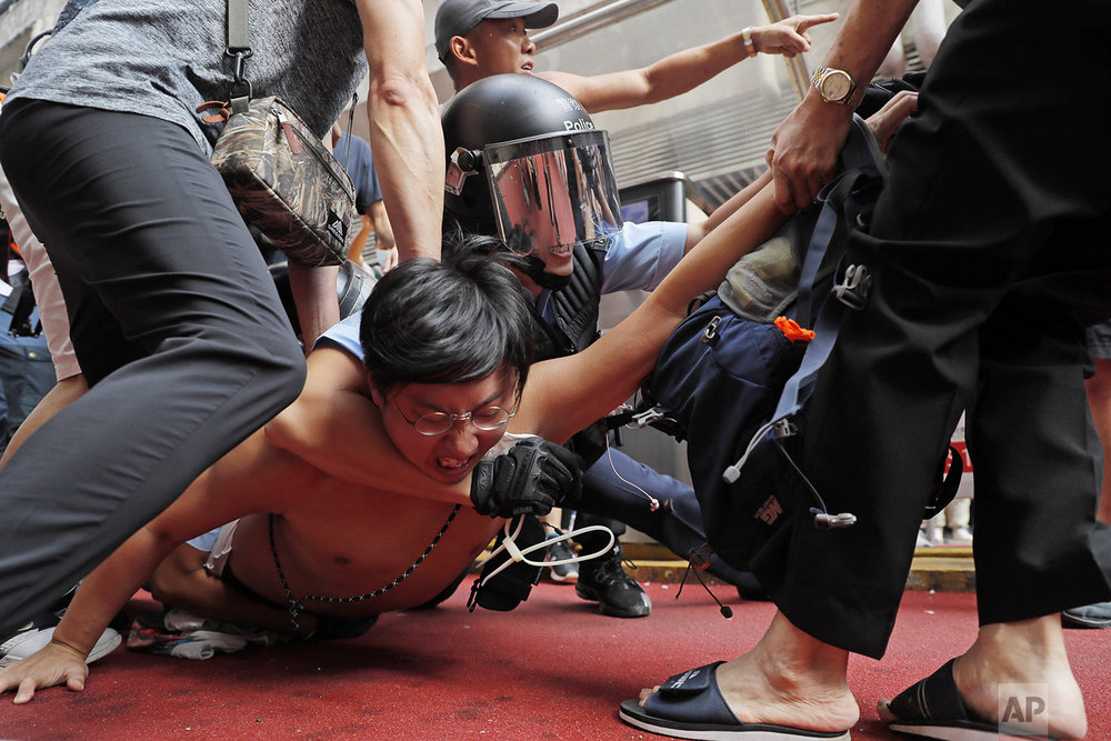 Police detain a man after fights broke out between pro-China supporters and anti-government protesters outside the Amoy Plaza in the Kowloon Bay district in Hong Kong, Saturday, Sept. 14, 2019. (AP Photo/Kin Cheung)