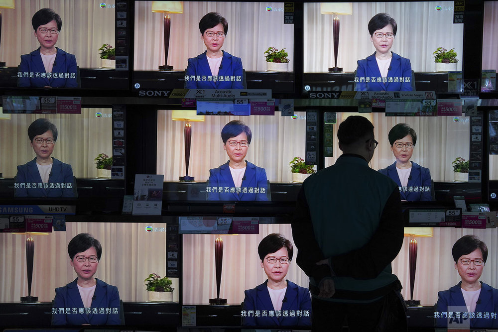 A man watches a television message of Hong Kong Chief Executive Carrie Lam making an announcement on the extradition bill, at a home electronics retailer in Hong Kong, Wednesday, Sept. 4, 2019. (AP Photo/Vincent Yu)