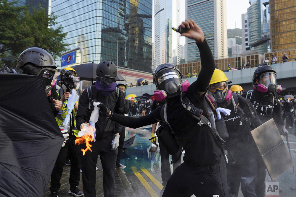 An anti-government protester throws a Molotov cocktail during a demonstration near Central Government Complex in Hong Kong, Sunday, Sept. 15, 2019. (AP Photo/Vincent Yu)