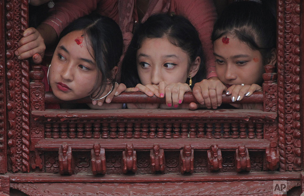 Former living goddess Kumari, center, watches the Indra Jatra festival, an eight-day festival that honors Indra, the Hindu god of rain, in Kathmandu, Nepal, Friday, Sept. 13, 2019. (AP Photo/Niranjan Shrestha)