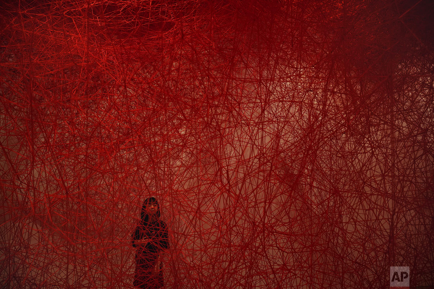  A woman looks at Chiharu Shiota's art installation titled "Uncertain Journey" at the Mori Art Museum, in Tokyo, Thursday, Sept. 19, 2019. (AP Photo/Jae C. Hong) 