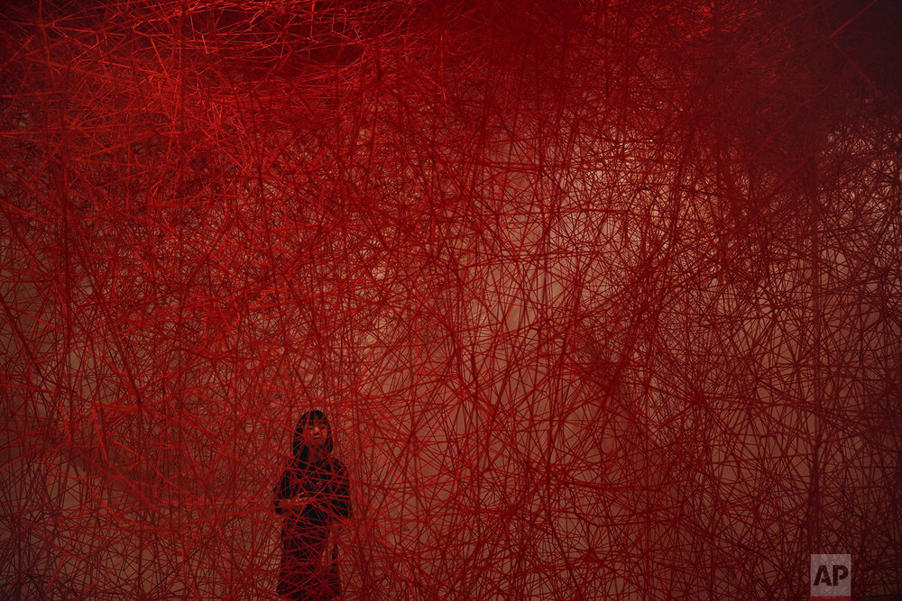  A woman looks at Chiharu Shiota's art installation titled "Uncertain Journey" at the Mori Art Museum, in Tokyo, Thursday, Sept. 19, 2019. (AP Photo/Jae C. Hong) 