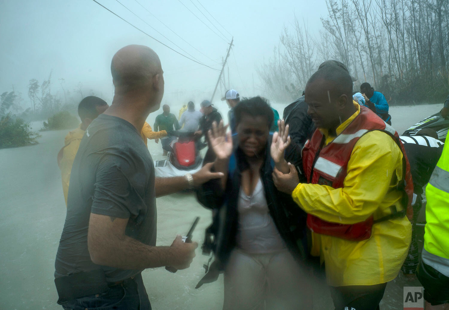 Volunteers rescue several families that arrived on small boats, from the rising waters of Hurricane Dorian, near the Causarina bridge in Freeport, Grand Bahama, Bahamas, Tuesday, Sept. 3, 2019. (AP Photo/Ramon Espinosa)