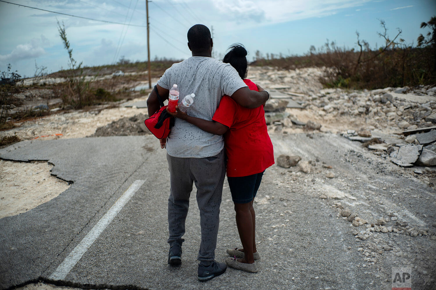  A couple embraces on a road destroyed by Hurricane Dorian, as they walk to the town of High Rock to try and find their relatives in the aftermath of Hurricane Dorian, in Grand Bahama, Bahamas, Thursday, Sept. 5, 2019. (AP Photo/Ramon Espinosa) 